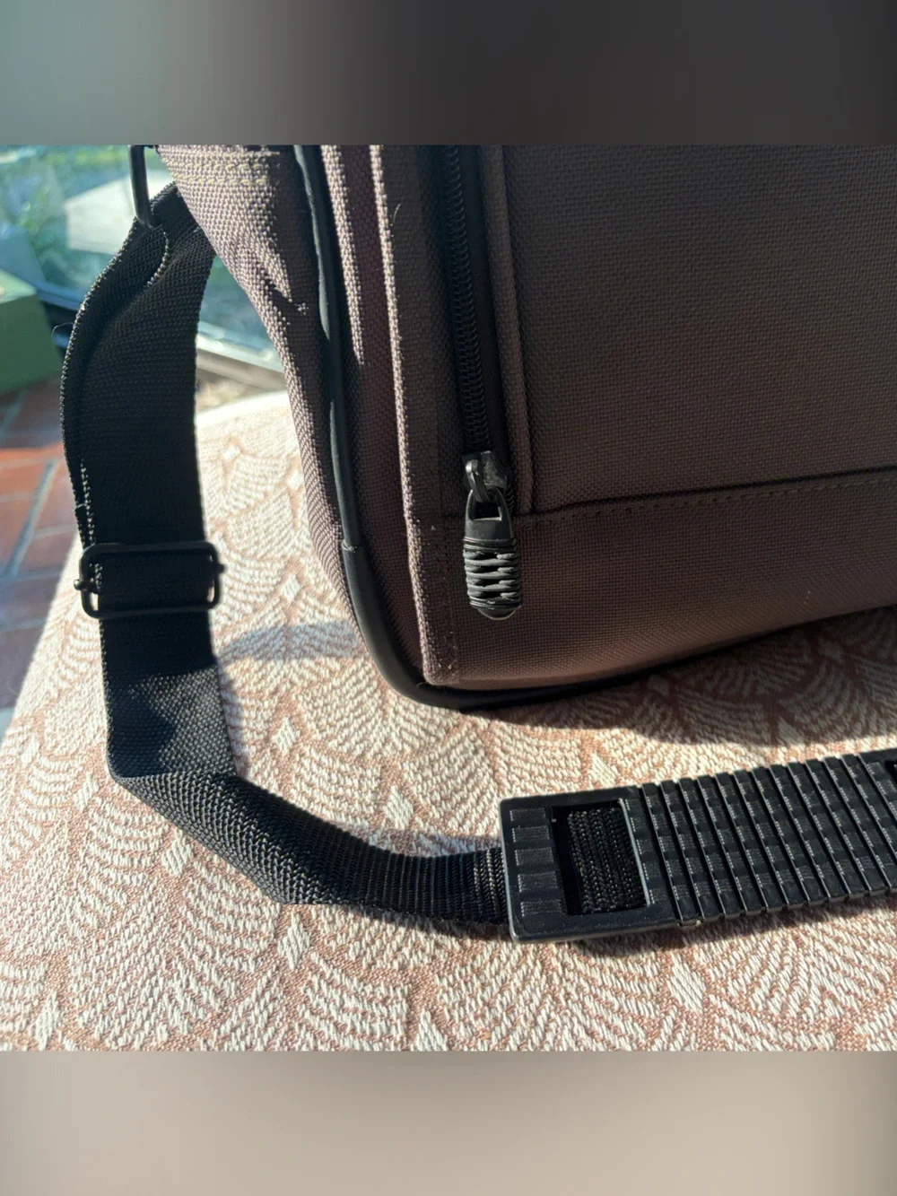 Eddie Bauer army green carry-on bag with black hand straps and shoulder strap